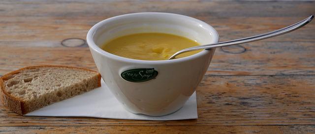 Bowl of vegetable pureed soup with half a slice of bread