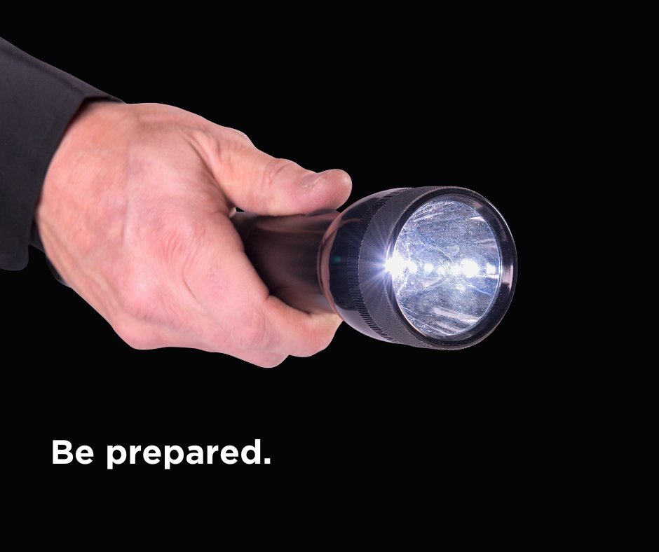 Closeup of hand holding flashlight with caption: "Be prepared"