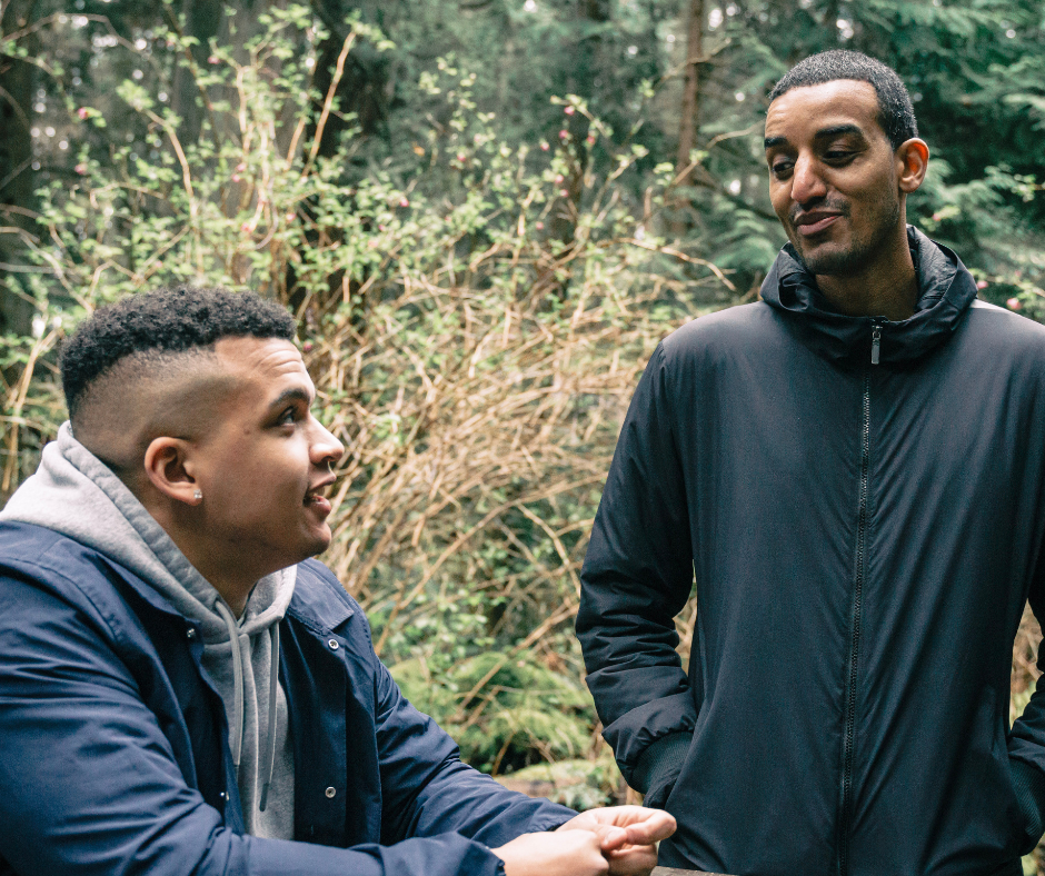 Two young men sitting outdoors talking