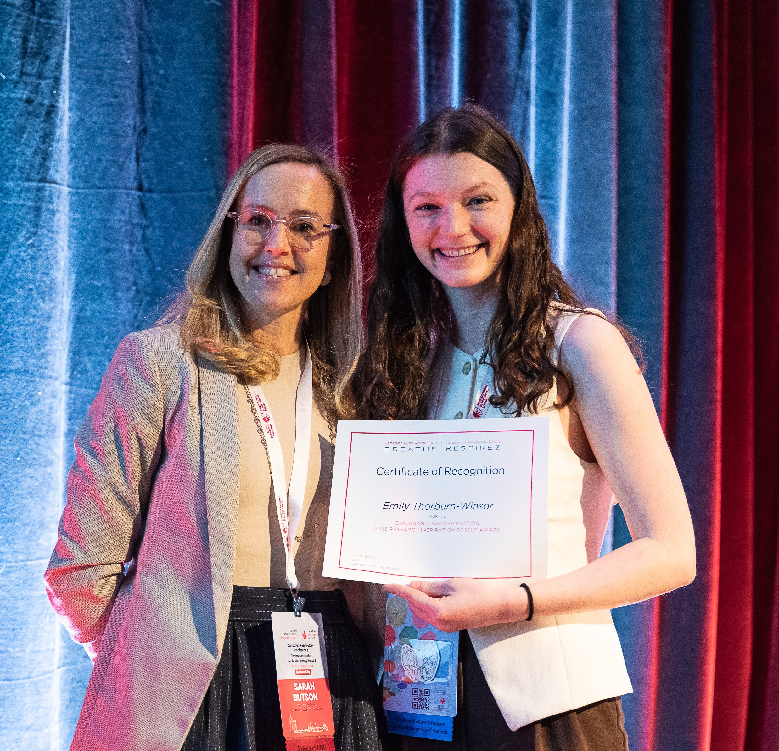 CEO Sarah Butson standing next to researcher Emily Thorburn-Winsor who is holding an award certificate